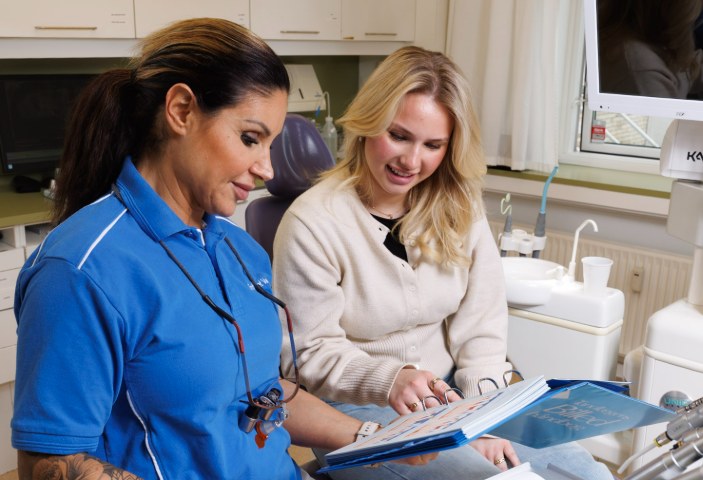 Klinikassistent viser en patient mulighederne i en mappe
